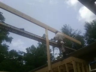 Carpenter setting a ridge beam over a new addition frame — Ice Dam Removal by Roofing Brothers in Bernhards Bay
